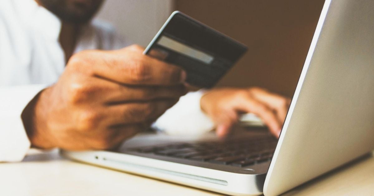 person holding credit card at computer